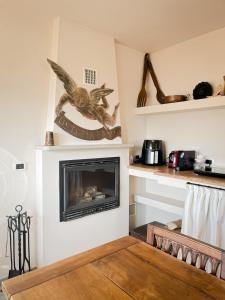 a living room with a fireplace with a bird on the wall at Casa Rosalinda, Monferrato cozy apartment in Camino