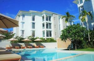 a hotel with a swimming pool in front of a building at Horizon Condo 1BR in Choeng Mon Beach