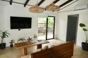 Una sala de estar con una mesa y un televisor. en Aduana - Beach House, en Santa Teresa Beach