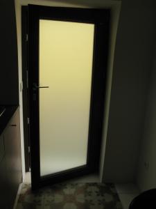a white door with a window in a room at B&B CASTANEA CASTELLUm in Castellaneta
