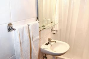 un bagno bianco con lavandino e specchio di Charming studio in Funchal, 30m², city view a Funchal
