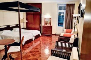 una camera da letto con un letto, una sedia e un tavolo di Charming studio in Funchal, 30m², city view a Funchal