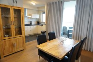 a kitchen and dining room with a wooden table and chairs at Kustverhuur, Appartement aan Zee, Port Scaldis 01061 in Breskens