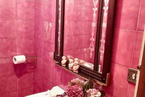 a pink bathroom with a mirror and flowers on a sink at Spacious house with terrace and balcony in A Coruña in A Coruña +26 photos