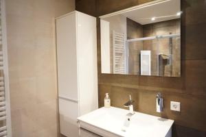 a bathroom with a white sink and a mirror at Kustverhuur, Appartement aan Zee, Port Scaldis 01061 in Breskens +15 photos