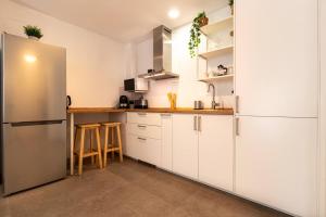 a kitchen with white cabinets and a stainless steel refrigerator at Charming Apartment in the Heart of Málaga in Málaga +19 photos
