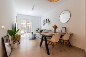 a dining room with a table and chairs and a mirror at Charming Apartment in the Heart of Málaga in Málaga