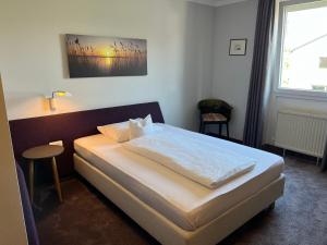 a bedroom with a bed and a window at Hotel Lachnerhof in Erlangen