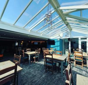 a dining room with wooden tables and chairs at 6 Berth Caravan with garden - Brightholme Holiday Park in Brean