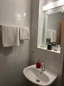 a bathroom with a sink and a mirror and towels at Hotel Lachnerhof in Erlangen
