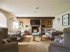 a living room with couches and a stone fireplace at The Plough Inn in Llandegla