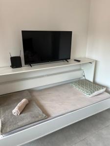 ein weißes Entertainment-Center mit einem Flachbild-TV darauf in der Unterkunft Aconchegante Apto Carapicuiba in Carapicuíba