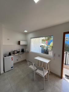 eine Küche mit Tisch und Stühlen in einem Zimmer in der Unterkunft Aconchegante Apto Carapicuiba in Carapicuíba