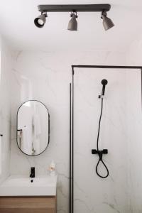 a bathroom with a shower with a mirror and a sink at Snagov Forest Villa in Ciolpani +15 photos