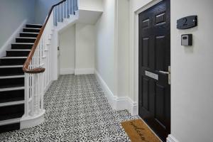 a hallway with a black door and a staircase at Host & Stay - Upton House in Northampton +12 photos
