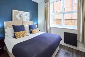 Un dormitorio con una cama con paredes azules y una ventana. en Host & Stay - Upton House, en Northampton 13 fotos más