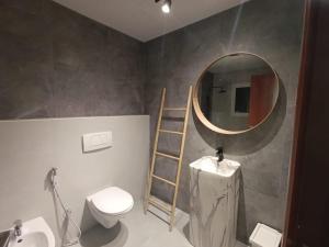 a bathroom with a toilet and a round mirror at In the heart of Dubai in Dubai
