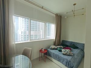 a bedroom with a bed and a table and windows at In the heart of Dubai in Dubai