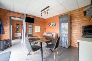 a kitchen with a table and chairs in a room at Chalet charmant à Saint-Sylvestre avec jardin 32 m² in Saint-Sylvestre