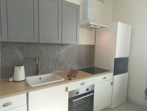 a kitchen with white cabinets and a sink at In the heart of Dubai in Dubai
