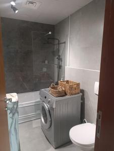a bathroom with a washing machine with baskets on it at In the heart of Dubai in Dubai +13 photos