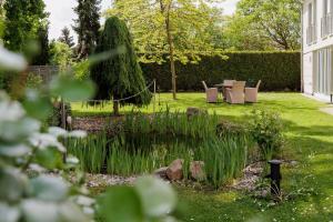 a garden with chairs and a pond in the grass at Landhotel Altes Wasserwerk GbR in Freinsheim