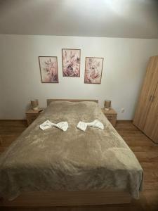 a bedroom with a bed with two slippers on it at Harmony Residence in Sfântu-Gheorghe +7 photos