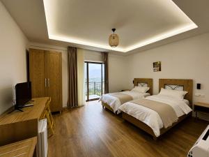 a hotel room with two beds and a television at Gle-Alb AgroTourism in Tepelenë +85 photos