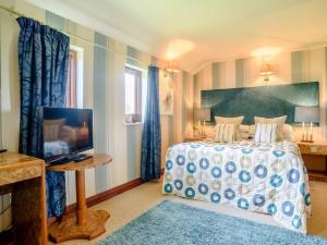 a bedroom with a bed and a flat screen tv at Stables Studio in Bedford