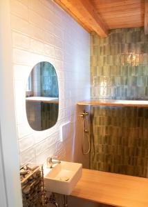 ein Badezimmer mit Waschbecken und Spiegel in der Unterkunft Designer Riverfront Cottage in Podljubelj + 16 Fotos