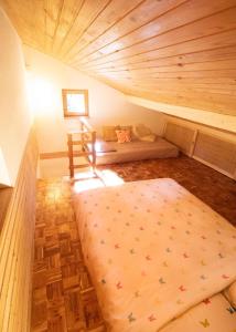 ein Zimmer mit einem Bett und einem Teppich auf einem Dachboden in der Unterkunft Designer Riverfront Cottage in Podljubelj