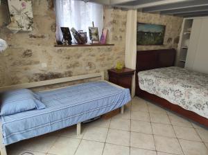 a bedroom with two beds and a window at Maison sur le causse du Quercy Lot 46 in Cremps