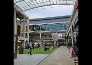 a group of people walking around a shopping mall at Cambridge Apartment at St Neot in Eaton Socon