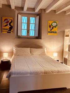 una camera con un letto bianco e due finestre di Capitolium Ad a Brescia