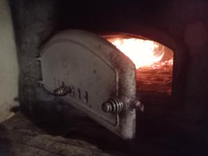 a stone oven with a fire in it at Pyrrön pirtti, koko talo in Oulainen