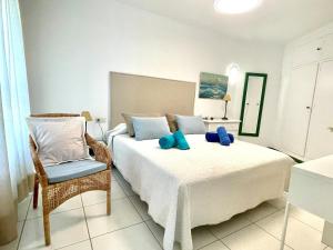 a bedroom with a white bed and a chair at Beachfront 75 in Torrox