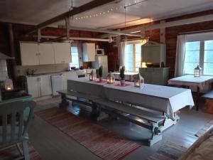 a kitchen with a large table in the middle of it at Pyrrön pirtti, koko talo in Oulainen