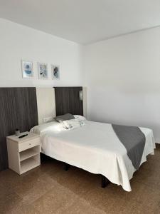 a bedroom with a white bed and a night stand at HOTEL MORELL in El Morell +11 photos