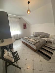 a bedroom with a bed and a table and a chair at Guesthouse Magdalena in Rakovica +6 photos