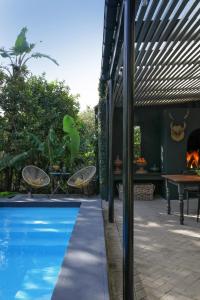 una piscina con pergolato accanto a una casa di The Black House a Robertson