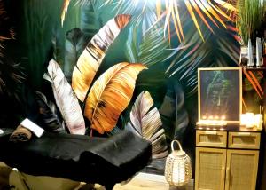 a room with a chair and a mural of feathers at Aparthotel Green Concrete - Free Beach Bus in Świnoujście