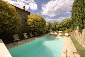 a swimming pool with chairs and a building at Villa La Pergola in Cortona