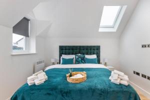 a bedroom with a large bed with a blue blanket at The Luxe 2Bedroom Saarb Apartment, Leatherhead in Leatherhead