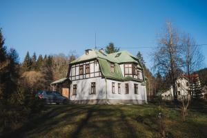 a large white house with a green roof at Vila Anobis in Nové Hamry