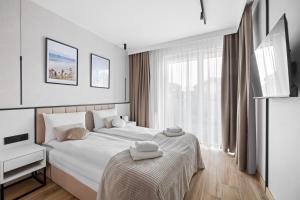a bedroom with a white bed and a window at Rezydencja Merwede Aparthotel - My Rest in Gdańsk