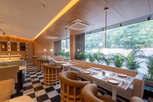 a restaurant with tables and chairs and a large window at Ramee ColleXtion Amritsar, Near Golden Temple in Amritsar