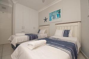Un dormitorio con dos camas con toallas encima. en 53 Sea Lodge Umhlanga Rocks, en Durban 19 fotos más
