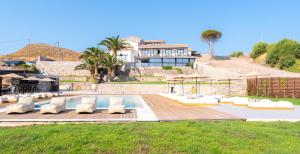 a villa with a swimming pool and a house at Hotel Angels in Mythimna