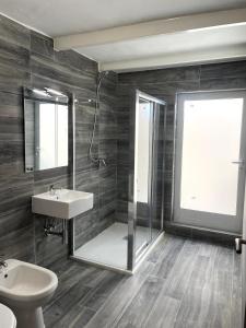 a bathroom with a sink and a shower and a toilet at The Old Mint House sleeps 15 in Valletta +17 photos