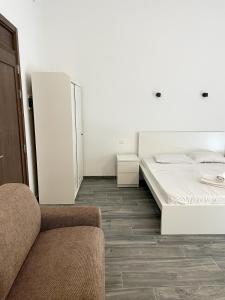 a white room with a bed and a couch at The Old Mint House sleeps 15 in Valletta